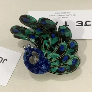 Peacock shaped acetate hair claw clip with rhinestones and elegant gold outlines