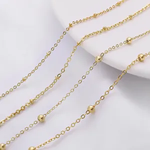 Detail of golden bead chain jewelry with polished finish and delicate link texture