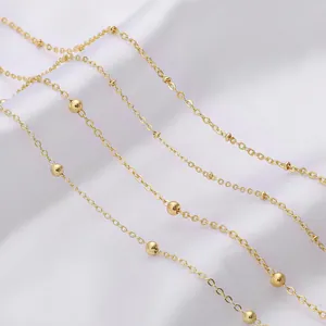 Detailed close-up of a gold-plated satellite chain for DIY jewelry making on white silk