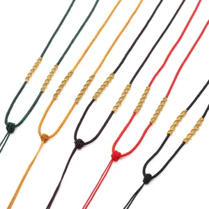 Détail de colliers en nylon tressé coloré avec des nœuds en spirale dorés en plusieurs couleurs