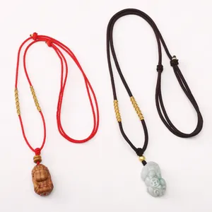 Détail de cordons de collier en nylon avec pendentifs Pixiu en jade et Bouddha en bois sculpté