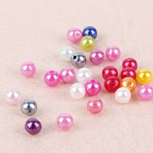 Bunte ABS-Perlen mit Löchern für DIY-Schmuck auf rosa Filzhintergrund für Bastelarbeiten