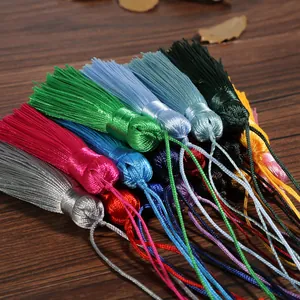 Colorful vintage silk tassels for DIY fan pendants and crafts on retro wood surface
