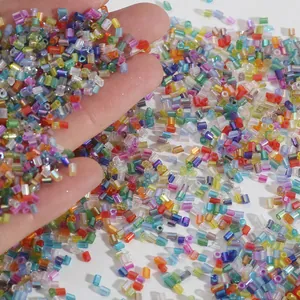 Colorful 2mm iridescent glass bugle beads for DIY jewelry making held in hand