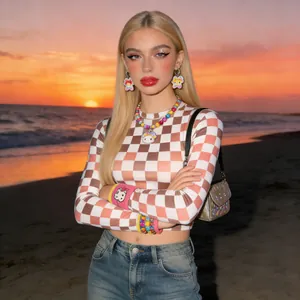 Brown and white checkered long sleeve top with Y2K style accessories on outdoor beach