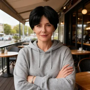 Outdoor shot of a casual grey hooded sweatshirt with drawstrings on a female model
