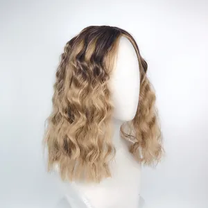 Detail of medium-length wavy wig featuring a seamless dark root to golden brown gradient