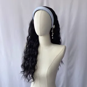 Dettaglio di extension capelli neri mossi con fascia per capelli azzurra su manichino