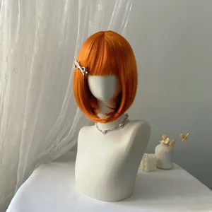 Short orange bob wig with bangs and silver bow clip on a white mannequin model
