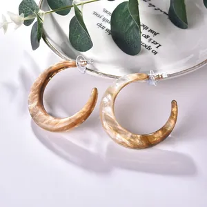 Elegant C-shaped tortoiseshell acrylic earrings with marbled brown resin texture on white