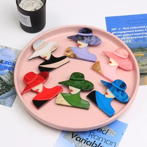 Set of six colorful acrylic lady silhouette brooches on a pink decorative tray