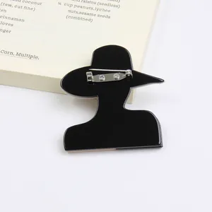 Detail of black acrylic silhouette brooch with secure silver metal safety pin back