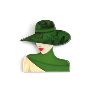 Detailed macro view of a vintage acrylic brooch featuring a lady portrait with green hat