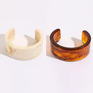 Close-up of translucent resin bangles with cream marble and amber tortoiseshell patterns