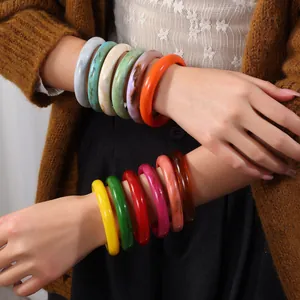 Stackable resin bangles with marble texture in vibrant colors worn by a model