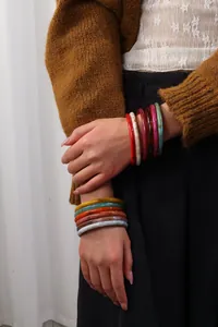 Primer plano de brazaletes de resina vintage con patrones de mármol en una modelo