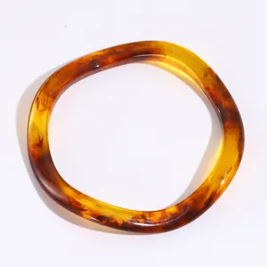 Bracciale in resina ambrata con trama marmorizzata e design irregolare a onde intrecciate