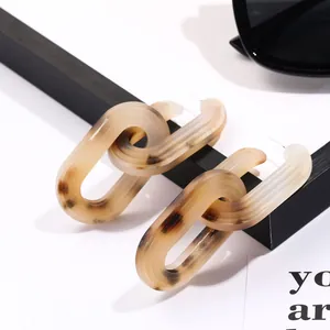Detail of tortoiseshell patterned acetate earrings with a double interlocking link design