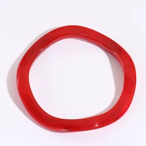 Dettaglio del bracciale rosso retrò in resina con bordi ondulati e trama in finto ambra