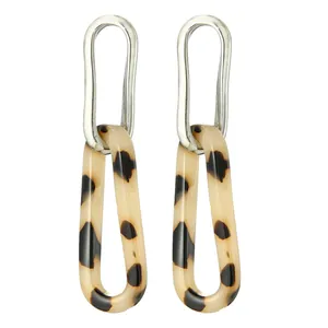 Close-up of tortoiseshell acetate flower earrings with silver metal oval link details