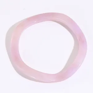 Dettaglio del bracciale in resina rosa traslucida con design a torsione organica