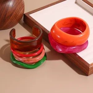 Translucent colorful resin oval bangles with marble texture in a stacked arrangement