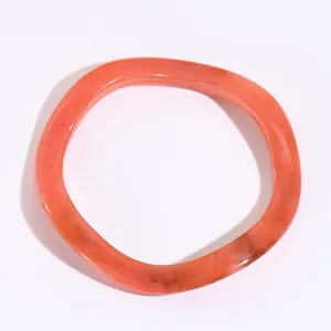 Dettaglio di un bracciale in resina corallo con trama a spirale ed effetto marmorizzato