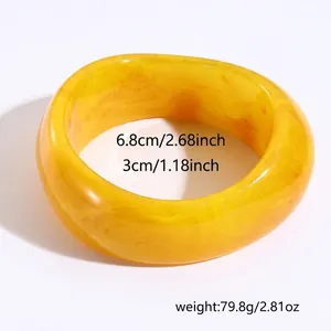 Dettagli del bracciale in resina gialla: diametro 6,8 cm, larghezza 3 cm e peso 79,8 g