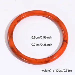 Detalle de las dimensiones del brazalete de resina veteada naranja con 6,5 cm de diámetro