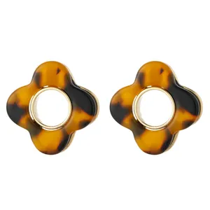 Macro detail of dark brown tortoiseshell acetate flower earrings with gold metal centers
