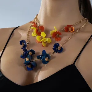 Détail macro d'un collier floral multicouche avec pétales en résine et base dorée