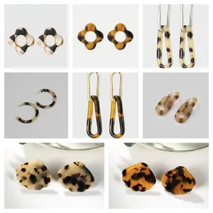 Collection of tortoise shell acetate earrings in floral and geometric shapes with gold accents