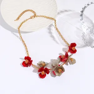 Collier chaîne dorée chic avec pendentifs fleurs en acrylique rouge et gris sur assiette