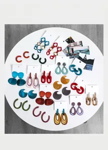 Flat lay of vintage acrylic geometric earrings in various colors on white display board