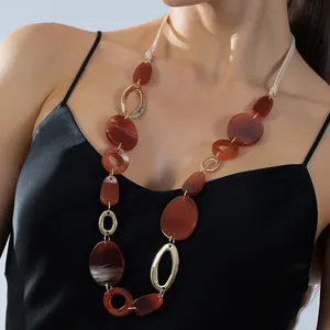 Sautoir géométrique avec résine rouge-brun et anneaux dorés de style bohème chic