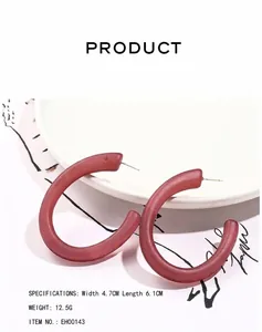 Detail view of large matte pink acrylic C-shape hoop earrings with measurements shown