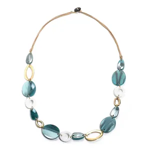 Détail du collier géométrique en résine acrylique avec motif marbré et anneaux dorés