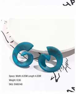 Detail view of blue acrylic spiral earrings with marble pattern 4.2cm in diameter
