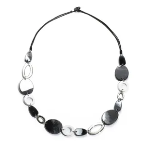 Détail de perles géométriques en acrylique noir et blanc avec textures marbre sur le collier