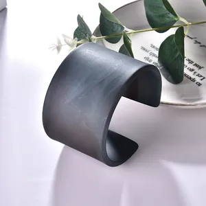 Brazalete ancho minimalista con patrón de mármol en negro mate y textura blanca