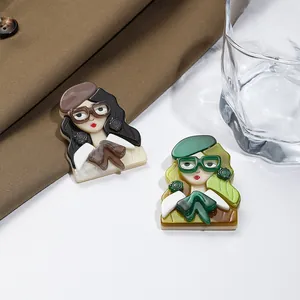 Gros plan de broches rétro en acrylique représentant des femmes avec bérets et lunettes