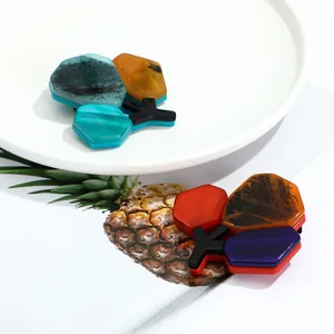 Detail of colorful acrylic brooches with marble texture and geometric hexagonal patterns