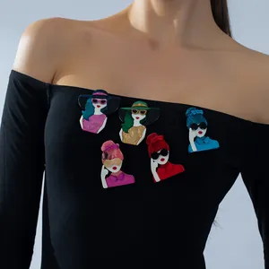 Five unique acrylic modern women head brooches set displayed on a black dress