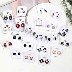 Collection of geometric acrylic and resin stud earrings on a white display card