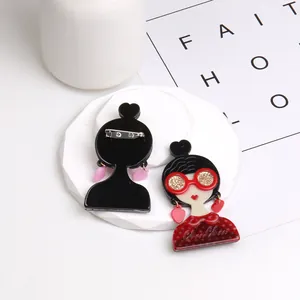 Détail d'une broche en acrylique montrant le design avant et l'épingle de sûreté arrière