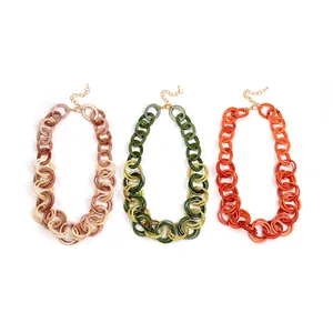 Three chunky acrylic link chain necklaces in marble brown, green and orange gradient