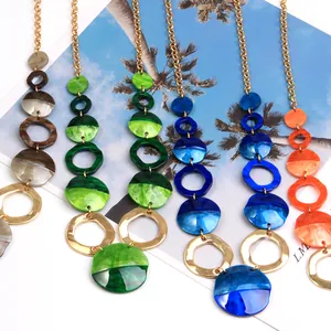 Schicke Acryl-Halsketten mit geometrischen Goldringen für einen sommerlichen Strandlook