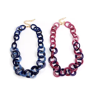 Close-up of resin acrylic circular chain link necklaces with marbled texture and gold clasp
