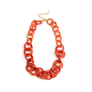 Detailed view of chunky orange acrylic link necklace with adjustable gold metal chain clasp