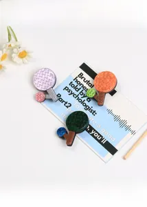 Detailed close-up of tree-shaped acrylic brooches with marble texture and wavy patterns